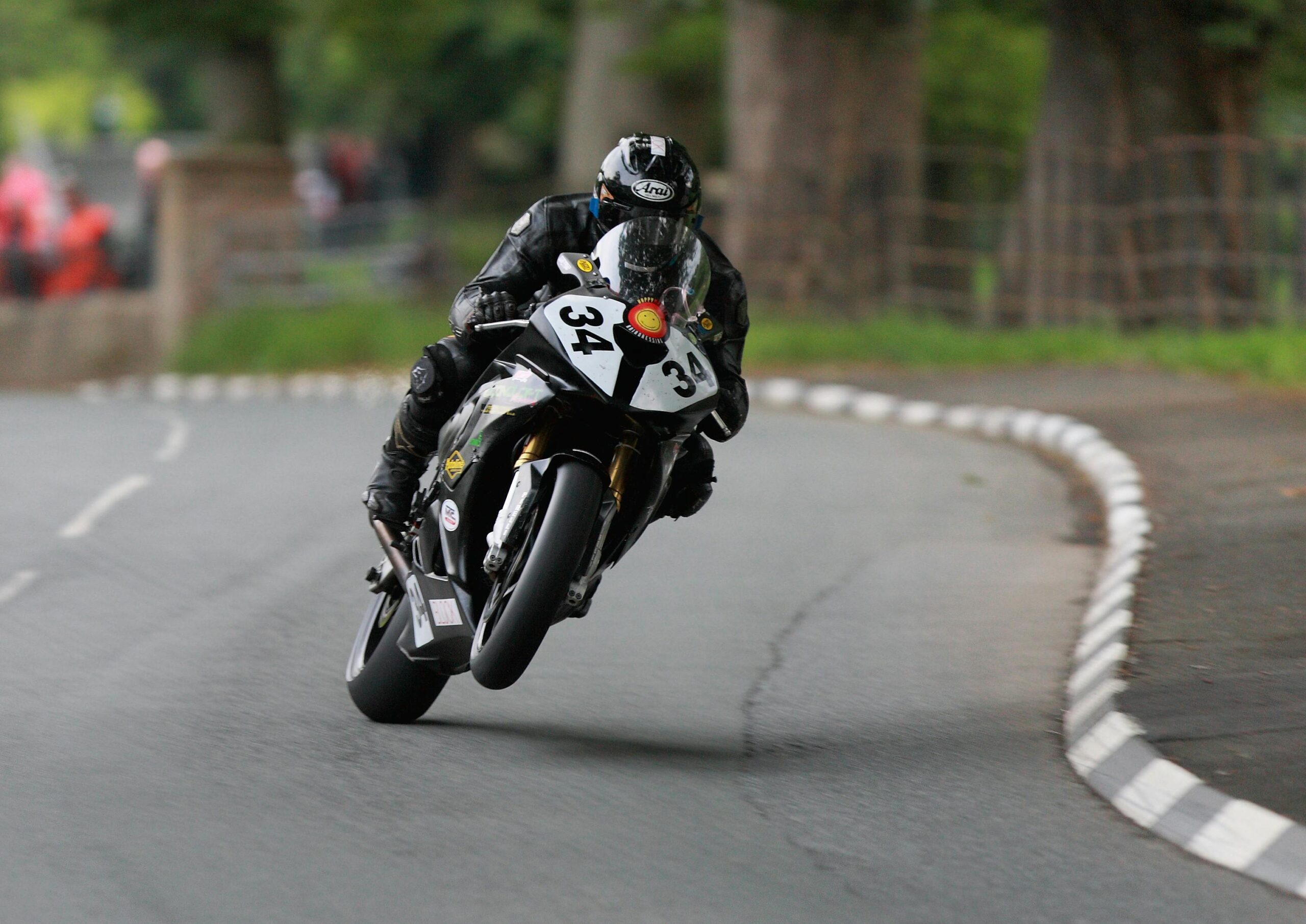 Dynamic shot of a motorcyclist speeding through the Isle of Man TT course.