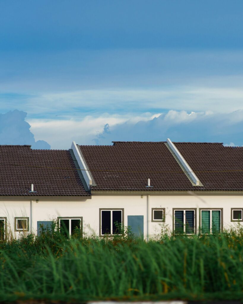 A row of modern houses with gabled roofs against a clear blue sky.