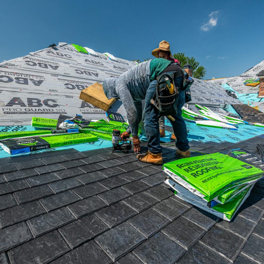 Workers installing a synthetic slate roof on a brick house in Fort Worth, Texas.